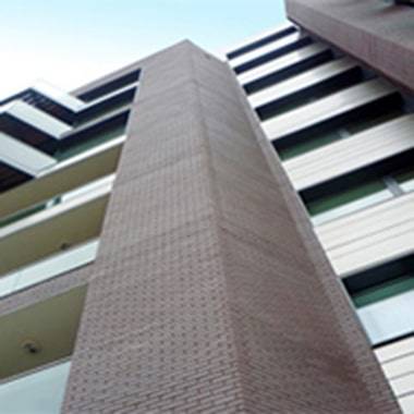 A brick building with windows and balconies.