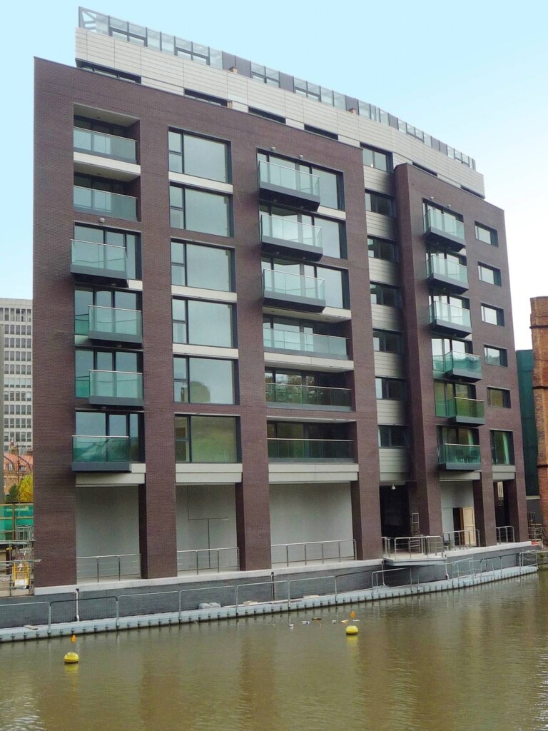 A brown building next to a body of water.