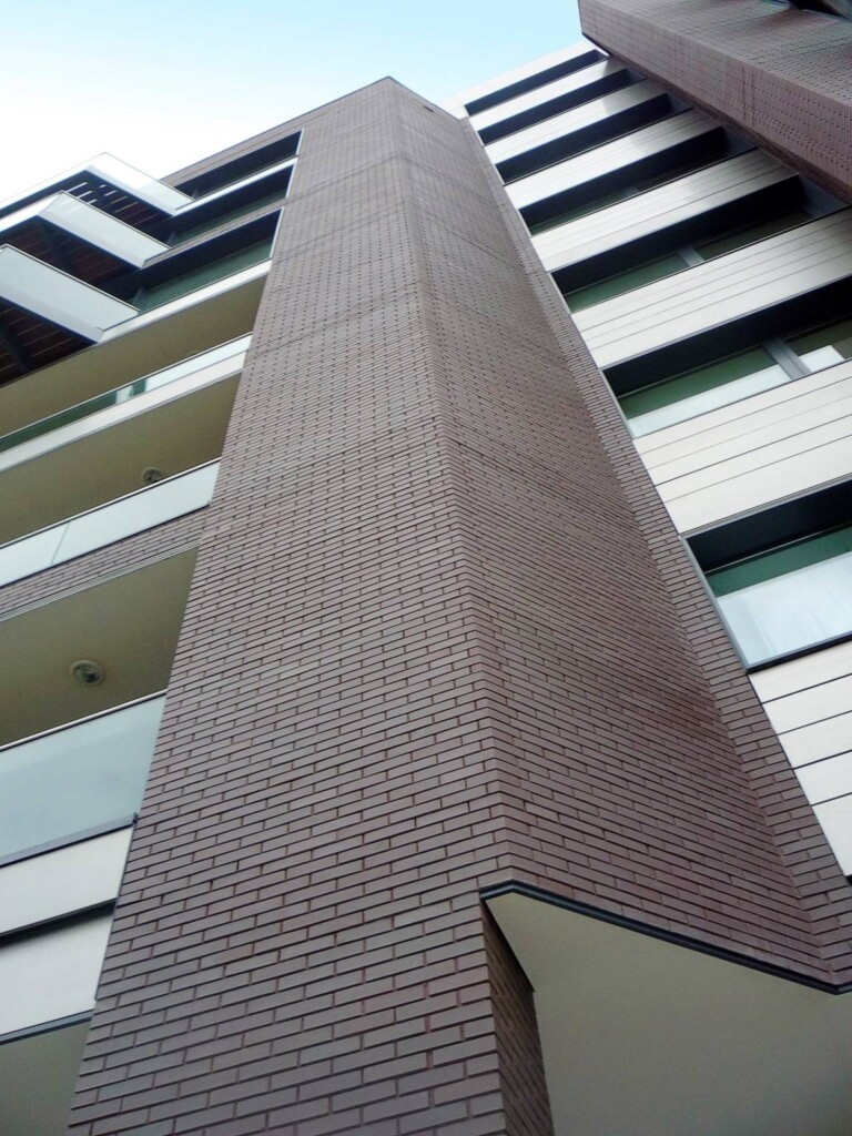 A brick building with many windows and balconies.