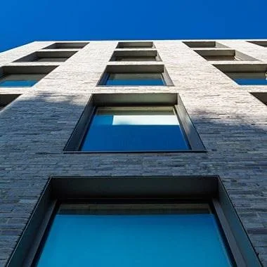 A building with many windows and a blue sky.