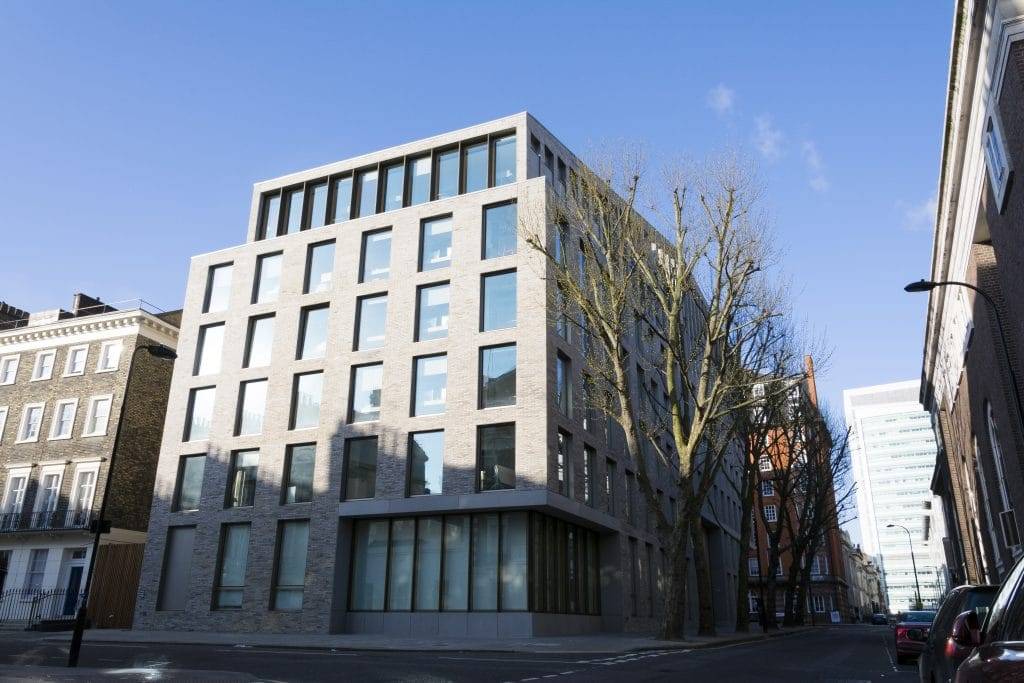 A grey building on the corner of a street.