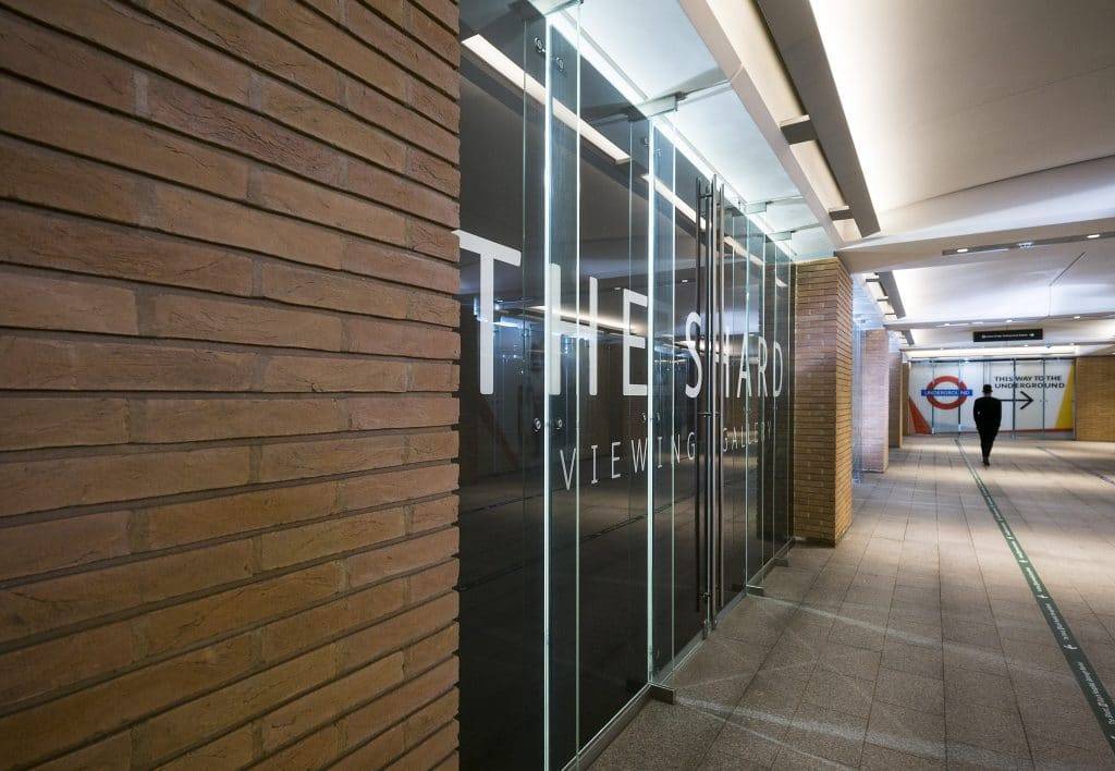 A person walking down a hallway with a sign on it.