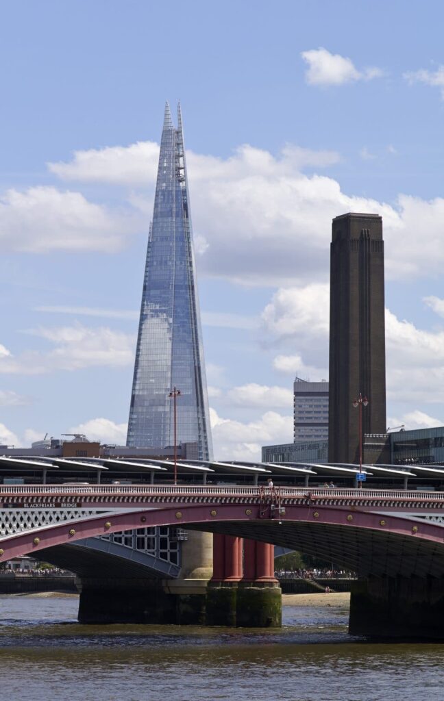 A bridge over water with a tall glass tower.