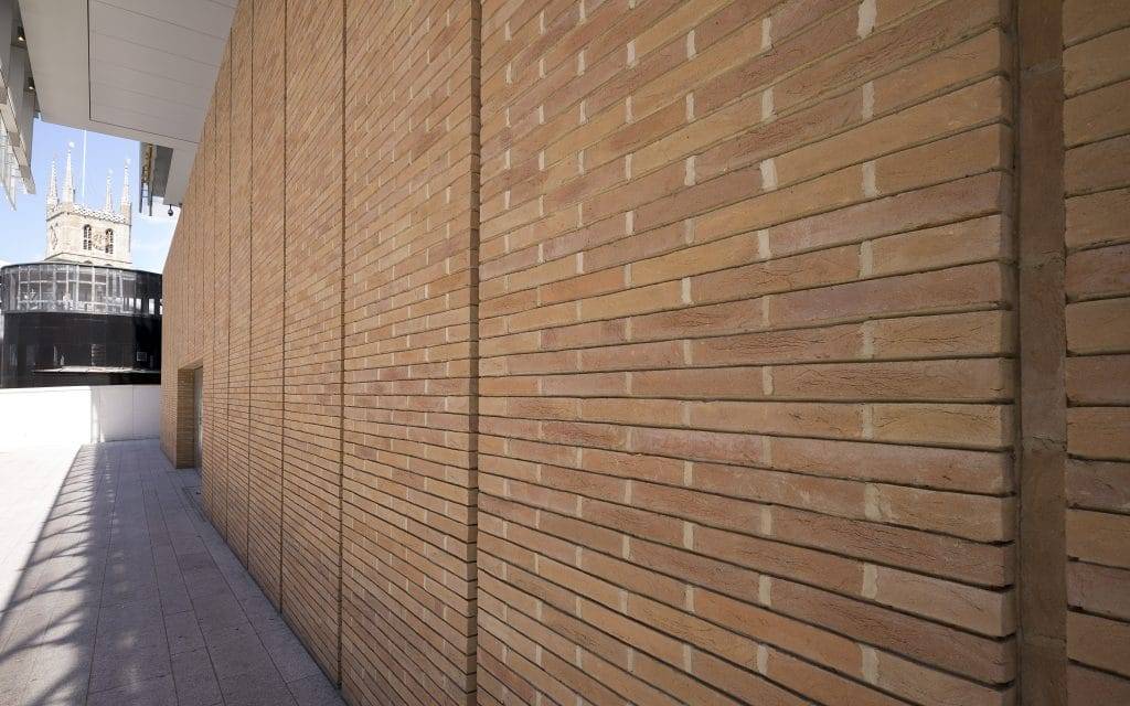 A brick wall in front of a building.