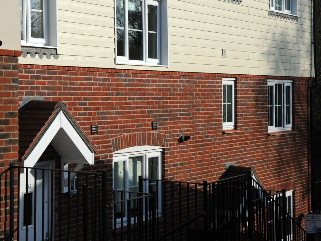 A red MCP1106 building with black railings.