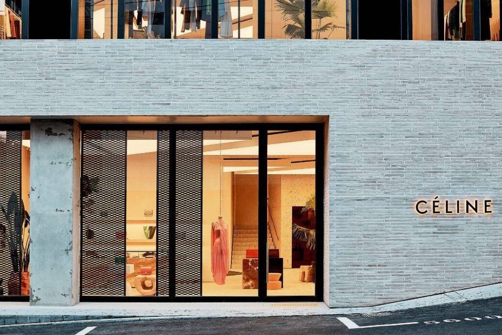 Exterior of a MCPV352 store with large windows, showcasing fashion items, built with textured brick walls and minimalist design.
