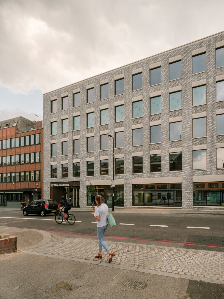 A modern building with a geometric facade of MCPV046 on a city street.
