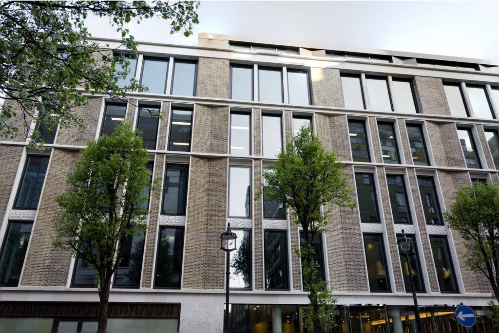 A building with many MCPM093 and trees in front of it.