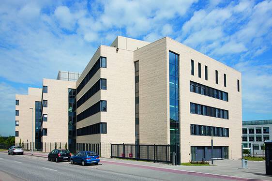 An office building with a MCPM115 parked in front of it.
