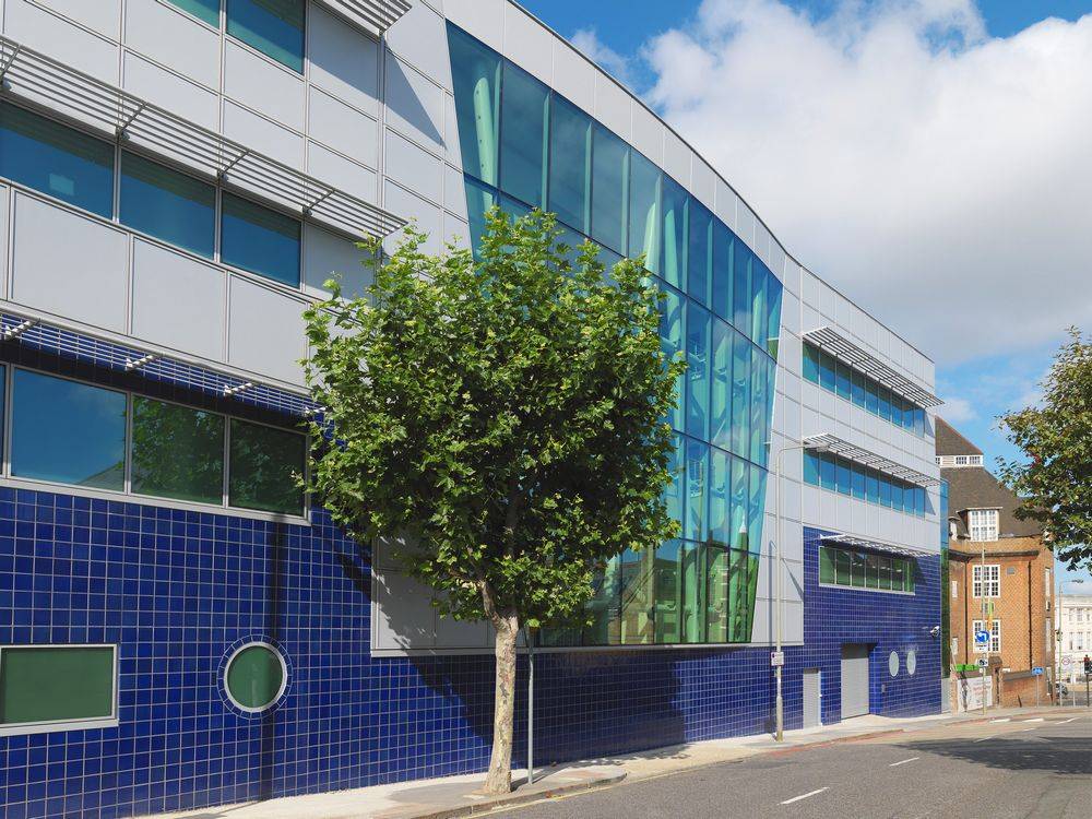 A blue and white building with a tree in front of it.