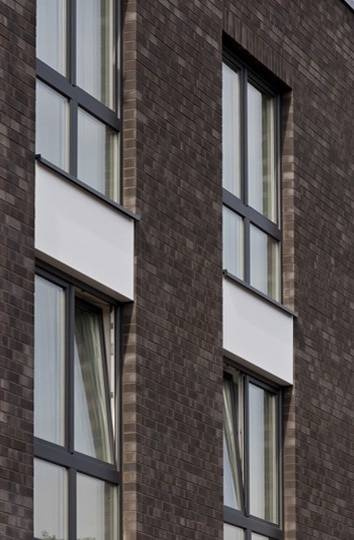 A brick building with windows and a MCPH043 clock.