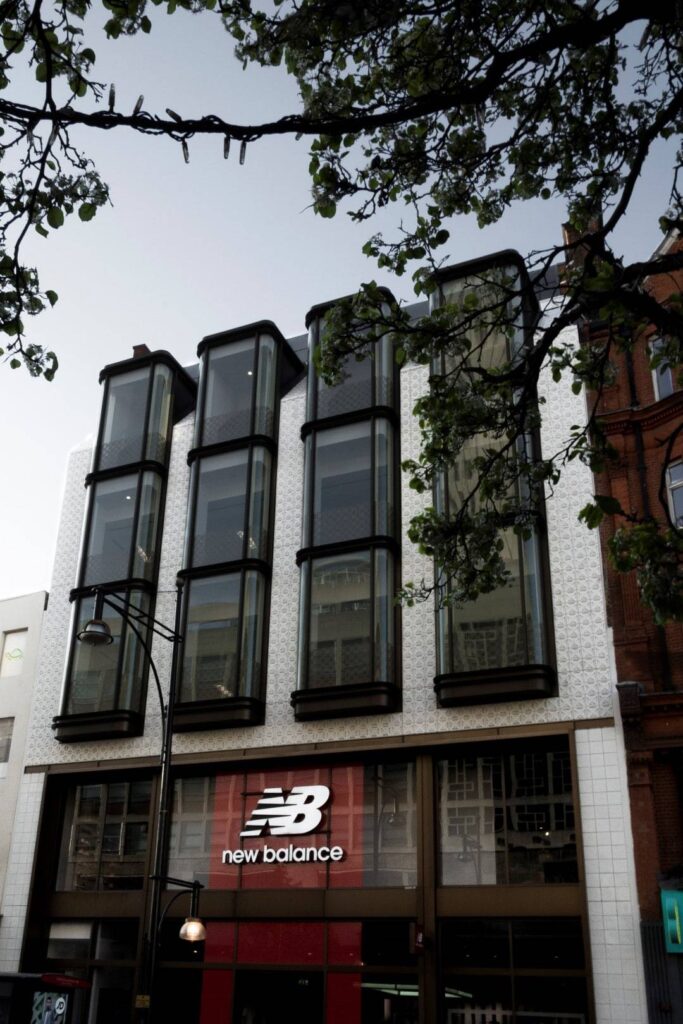 The new balance store is on the corner of a street.