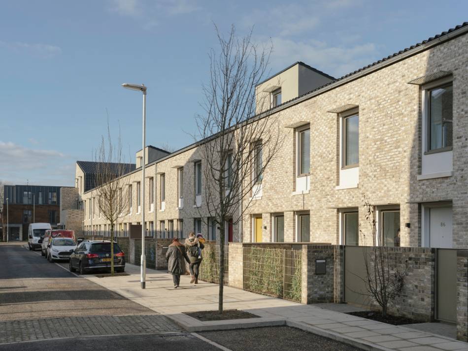 A row of brick townhouses on a street.