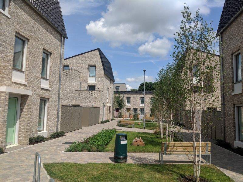 A courtyard with benches and trees in a residential area.