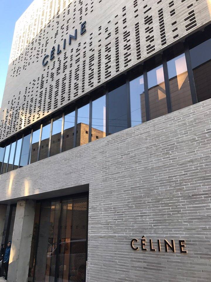 Modern celine store facade featuring a large, perforated sign on a building