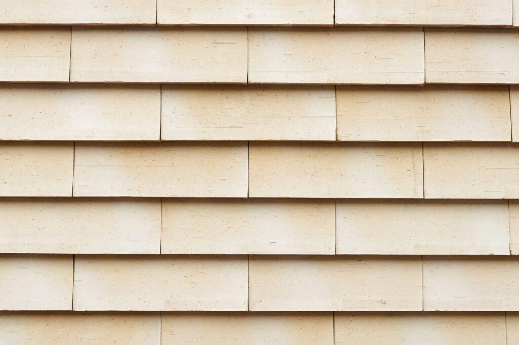 Close-up of a beige horizontal siding pattern on a wall.