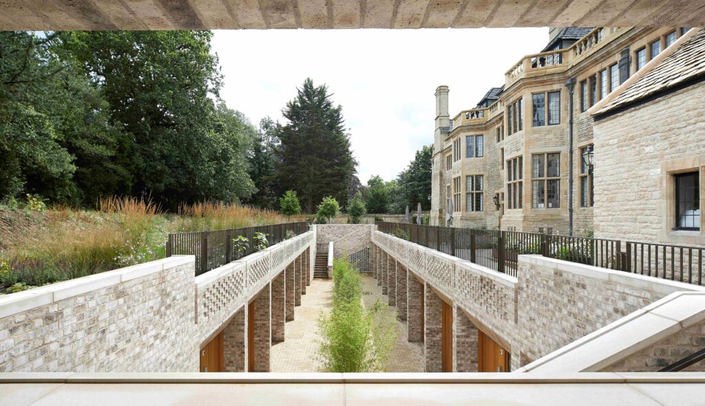 View of a restored historic building with brickwork, seen from a landscaped garden