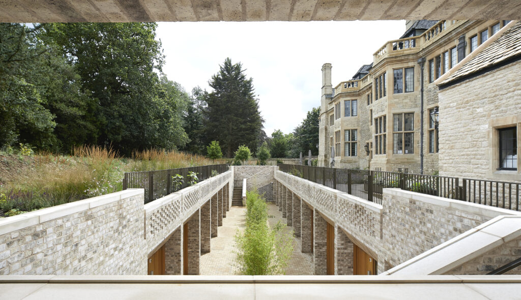 A view of an outdoor courtyard surrounded by stone buildings and lush greenery on a sunny day.