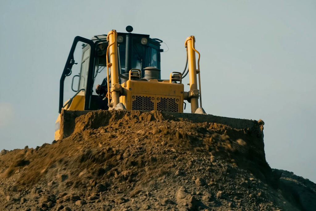 The first stage of clay brick manufacturing: a digger extracting raw clay at a quarry