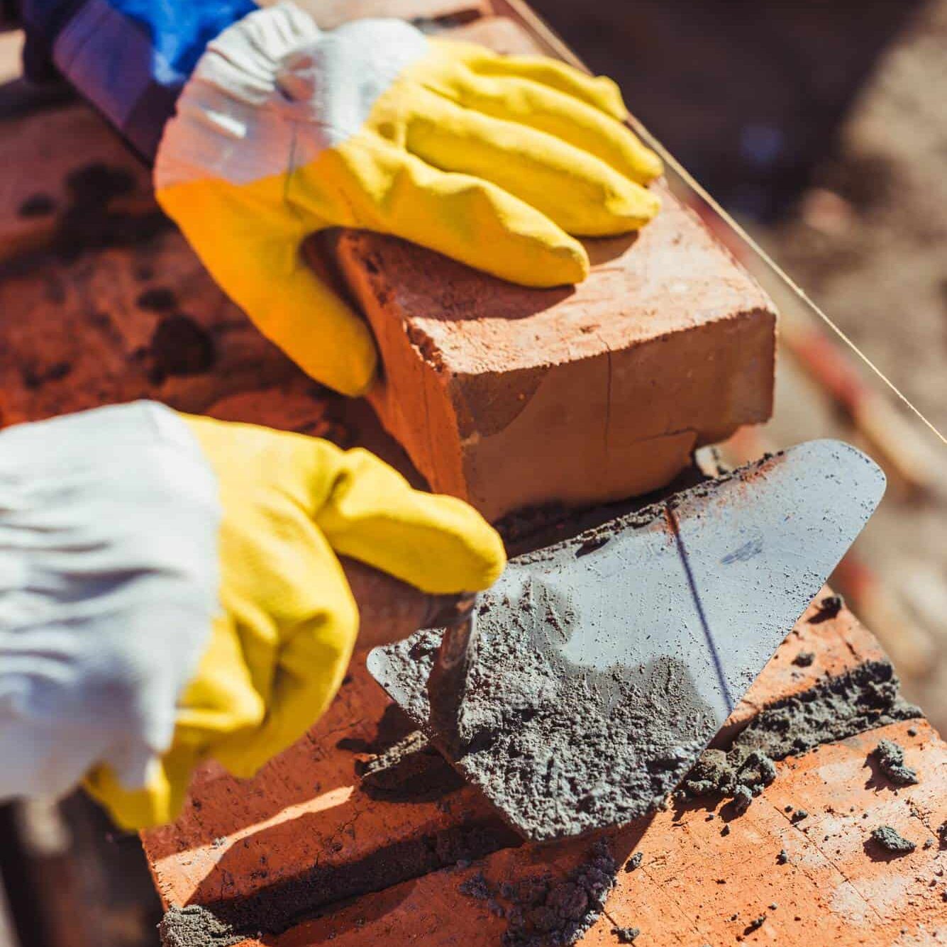 close up of builder laying bricks